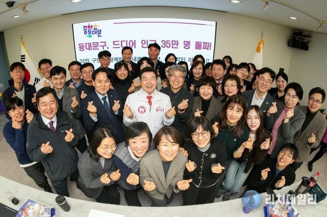 이필형 동대문구청장(가운데)이 직원들과 구민 35만 명 돌파를 자축하고 있다