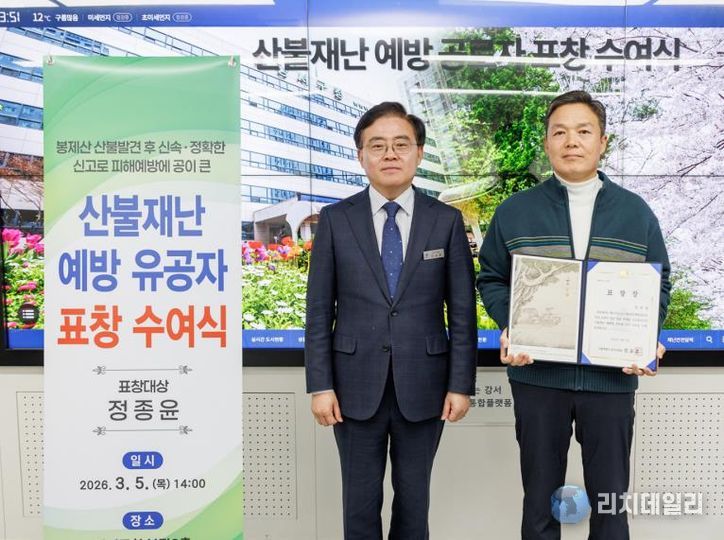 진교훈 서울 강서구청장(왼쪽)이 지난 5일 구청에서 열린 ‘산불재난 예방 유공자 표창 수여식’에서 신속한 신고로 초기 진화에 기여한 화곡동 주민 정종윤(57) 씨에게 표창을 수여하고 기념촬영을 하고 있다.