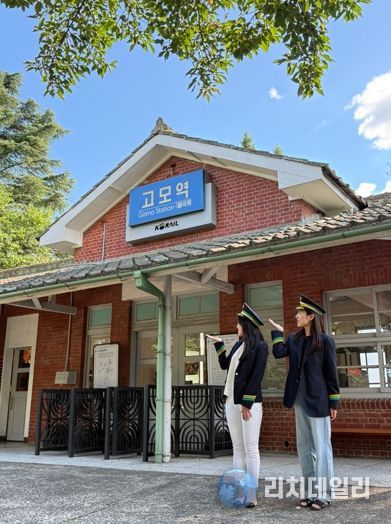 관광객들이 고모역에서 역무원 체험을 하고 있다.