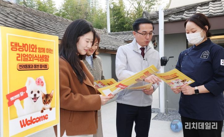 박희조 동구청장과 직원들이 반려견 동반음식점에서 설명을 듣고 있다